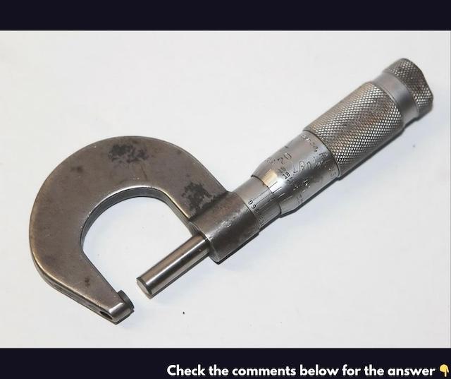 A close-up of a classic micrometer, showing its precise dial and robust metal frame. Once an essential tool in every workshop, this instrument helped ensure accuracy in mechanical work